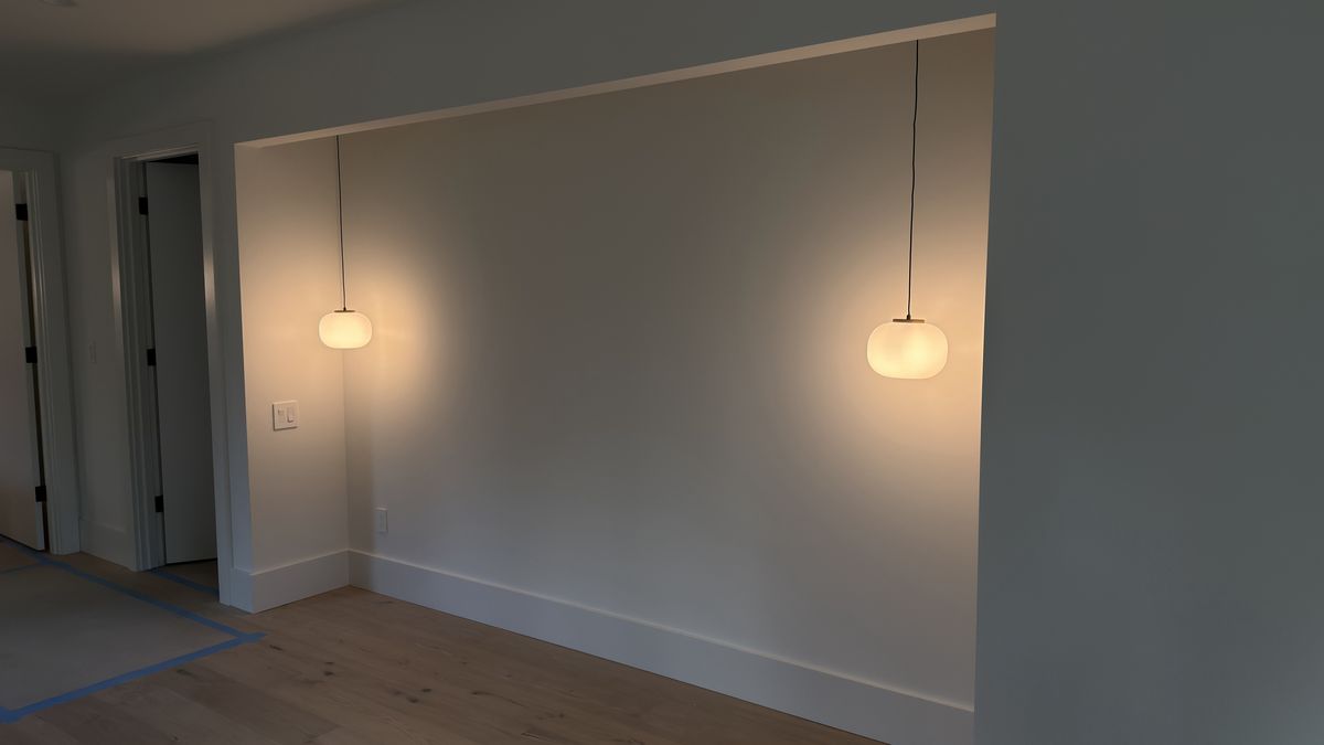 Two glass pendant lights hanging in a recessed alcove