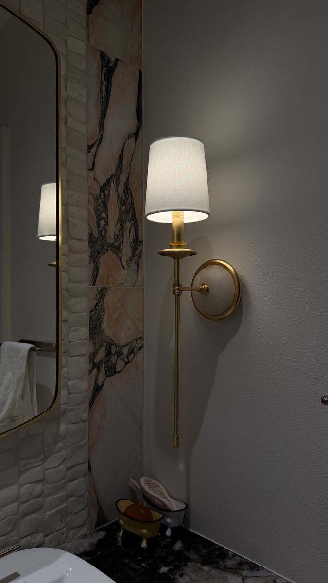 Brass bathroom wall sconce with a fabric shade