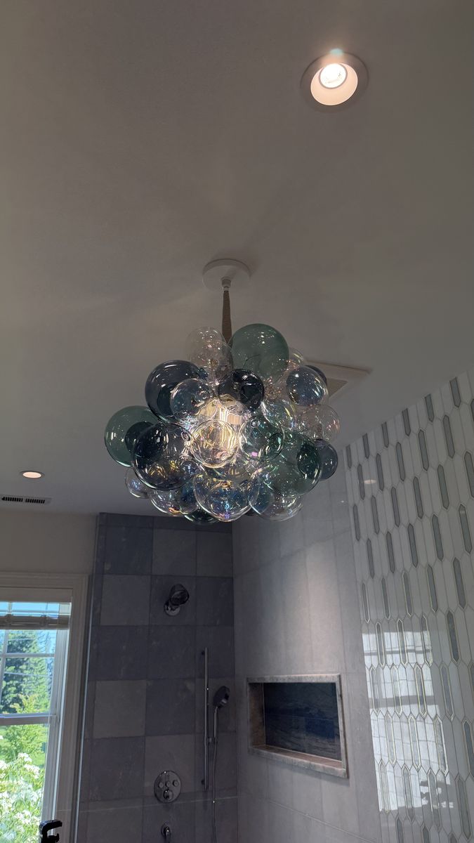 Bubble glass chandelier with recessed ceiling lights in a bathroom