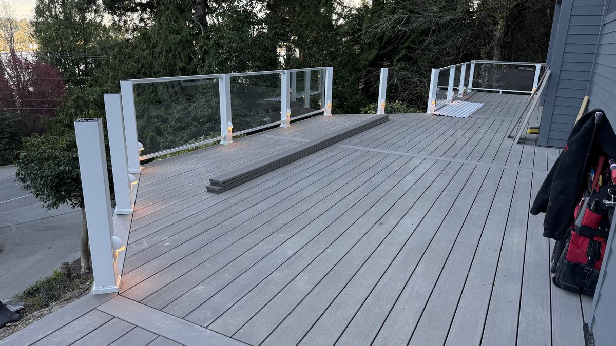 Low-voltage post lights along a deck with a glass railing