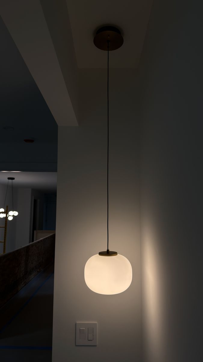 Single glass pendant light above a wall-mounted dimmer switch